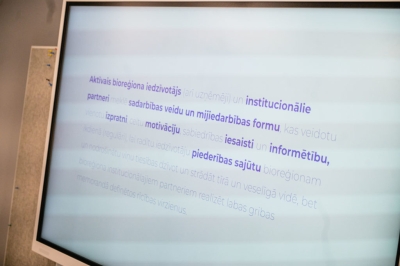 Ekrānā redzama prezentācijas lapa par bioreģiona iedzīvotāju un partneru sadarbību.